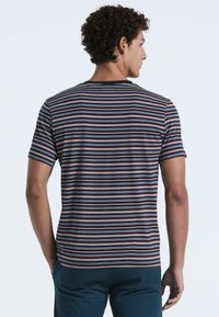 Gestreepte crew neck t-shirt in marineblauw, rood en wit. Korte mouwen, normale pasvorm en zachte stof. De achterkant toont horizontale strepen.