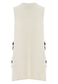 Sleeveless vest in cream, made of soft, textured fabric; features black fringe accents along the sides; straight hemline.