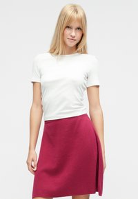 Λευκό ριμπ ζιβάγκο με κοντά μανίκια συνδυασμένο με μπορντό φούστα σε γραμμή Α με πλευρική σκίσιμο. Ομαλή υφή και απλός σχεδιασμός.