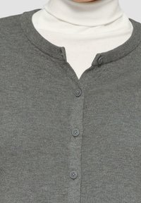Grauer Strickcardigan mit rundem Ausschnitt und drei Knöpfen, der eine weiche Textur und ein tailliertes Design aufweist. Die Basislage erscheint weiß.