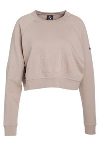 Sweatshirt beige Nike court avec lettrage texturé "Just Do It". Comprend des manches longues, des poignets côtelés et un col rond.