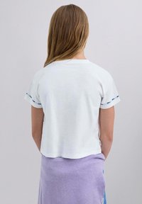 Weißes kurzärmliges T-Shirt mit lockerer Passform, das bunte Nähte an den Ärmelbündchen aufweist. Der Stoff wirkt leicht und leicht strukturiert.