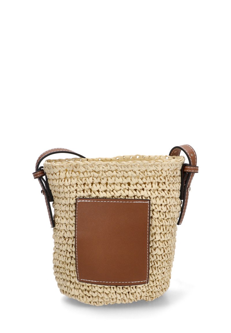 Bolso de cubo tejido en paja de color crema, con un parche de cuero marrón, dos asas de cuero y un acabado texturizado.