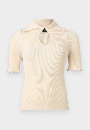 Roomkleurige, geribbelde top met korte mouwen, een opgevouwen kraag en een sleutelgatuitgesneden detail onder de halslijn, met golvende mouwranden.