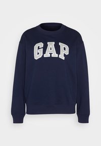 Sudadera azul marino de algodón, con un logo bordado de "GAP" en blanco y gris, con puños y dobladillo acanalados, y cuello redondo.