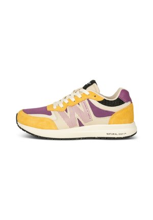 Niskie sneakersy z fioletową tkaniną, żółtymi zamszowymi nakładkami, kremowymi akcentami, białymi sznurowadłami i fakturowanym czarnym detalem pięty na białej podeszwie.
