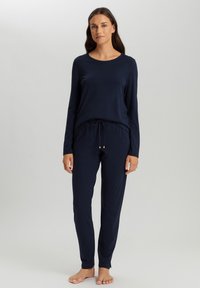 Navyblauwe longsleeve top met ronde hals, gecombineerd met bijpassende joggerbroeken met een elastische tailleband en trekkoord met gouden accenten.