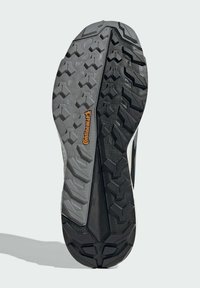 Shoe outsole featuring a black and gray rubber design with a textured tread pattern and "Continental" logo in orange, providing grip.