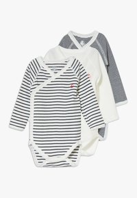 Tre bodysuit a maniche lunghe: uno bianco con righe blu navy, uno a righe blu navy e uno bianco. Ognuno ha un design avvolgente e chiusure a scatto.