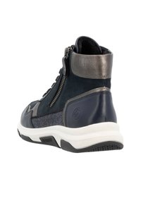 Baskets montantes en daim bleu marine et gris avec des accents métalliques, dotées d'une fermeture éclair sur le côté, de détails texturés et d'une semelle en caoutchouc blanche.