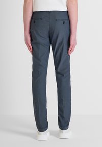 Pantalones azul marino de tejido texturizado, con dos bolsillos traseros con botones, diseño ajustado y acabado suave.