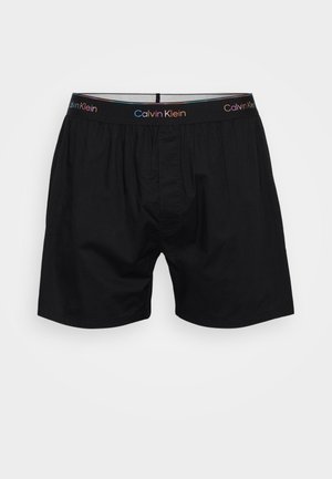 Sorte bomuldsboxershorts med en elastisk talje med et flerfarvet "Calvin Klein" logo, klassisk snit og en åbning foran.