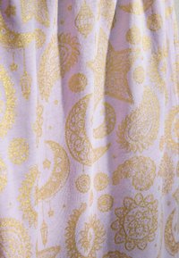 Tissu violet avec des motifs pailletés dorés comprenant des étoiles, des croissants de lune, des formes cachemire et des lanternes suspendues.