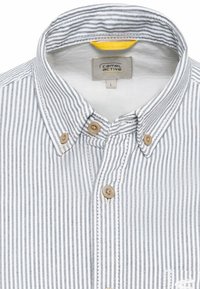 Chemise à rayures à boutons blancs et bleu marine. Elle possède un col, deux boutons bruns et une étiquette avec "Camel Active" en jaune. Matière en coton.