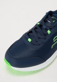 Navy athletic shoe with a textured upper, green accents, and a white sole. Features a lace-up design and a padded collar for comfort.