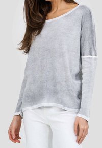 Ljusgrå långärmad topp av mjukt, strukturerat material med vid rund halsringning och kontrasterande vita detaljer vid ärmar och nederkant.