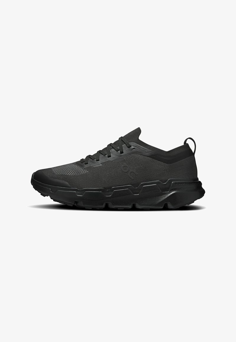 Chaussure de sport noire avec bout texturé, semelle rembourrée et design à lacets, avec languette au talon et logo latéral discret.