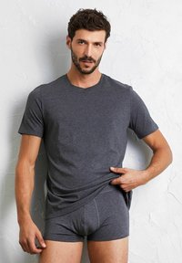 Grå T-shirt med kort ärm i mjukt material och rund halsringning, kombinerad med grå boxertrosor med en subtil elastisk midja.