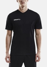 Camisa deportiva negra de manga corta con diseño de cuello en V. Presenta el logotipo "CRAFT" en blanco en la parte izquierda del pecho. Material sintético suave.