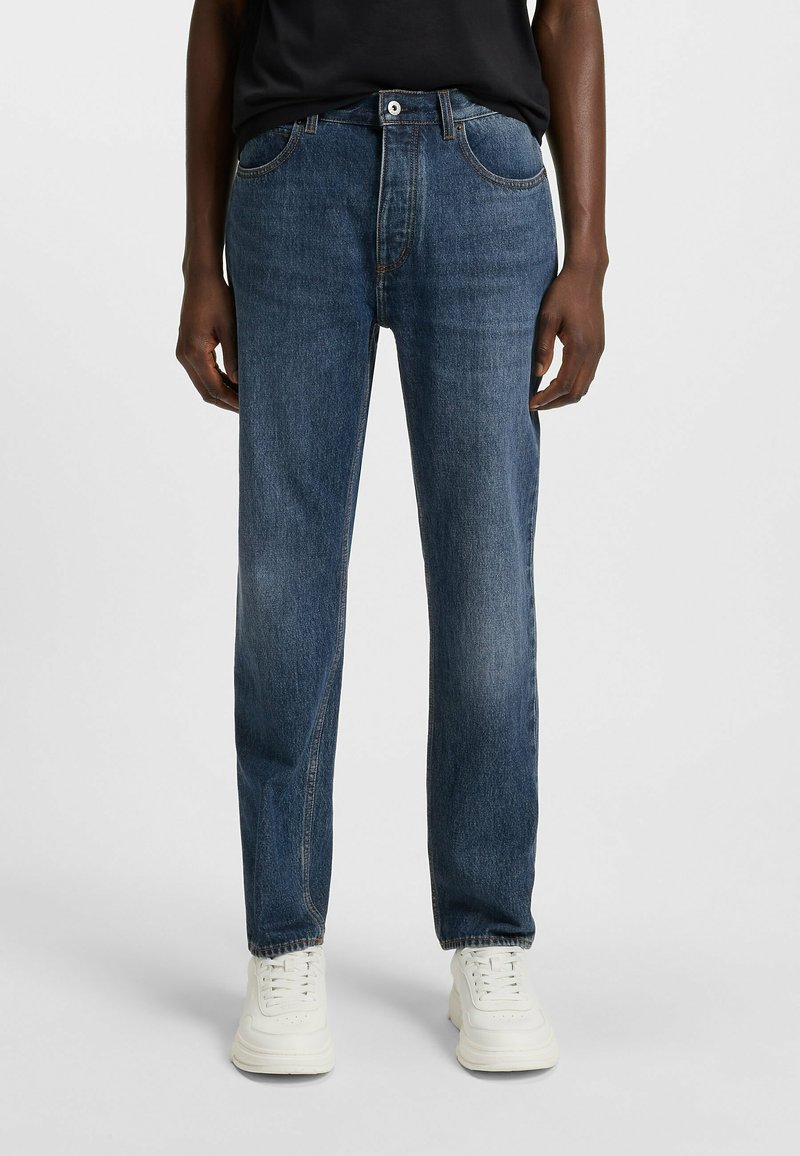 Dark blue denim jeans with a straight leg design, featuring front pockets, a button closure, and visible stitching accents.