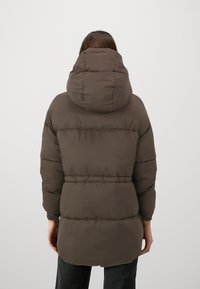 Vattert brun parka med hette, med horisontale sømmer og innsnevring i midjen. Glatt, skinnende materiale med elastiske mansjetter.