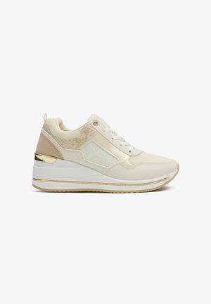 Zapatilla deportiva para mujer en beige y blanco con paneles de malla y textura, cordones blancos, suela gruesa con plataforma y detalles en dorado.