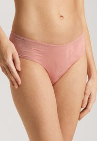 Světlé růžové krajkové kalhotky typu hipster s květinovým vzorem, hladkou texturou a elastickým pasem. Viditelné švy podtrhují okraje.