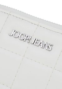 Portafoglio bianco in pelle con motivo trapuntato, logo "JOOP!JEANS" in argento e chiusura con cerniera. Finitura testurizzata con dettagli di cucitura visibili.