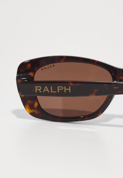 Slnko-ochranné okuliare v štýle tortoiseshell s odváznym rámom, hnedými zafarbenými sklami a zlatým brandovaním "RALPH" na boku. Hladký, lesklý povrch.