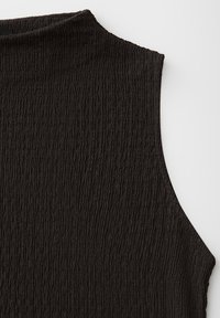 Top noir sans manches avec des rayures verticales texturées et un col montant, présenté à plat sur une surface blanche.