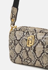 Bolso de mano con estampado de serpiente en beige y marrón, con cierre de cremallera, herrajes en tono dorado y una correa trenzada. Superficie texturizada con un patrón de diamantes.