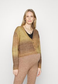 Cardigan em degradê castanho com decote em V, mangas longas e botões frontais, feito de material suave. Combinado com leggings castanhas a condizer.