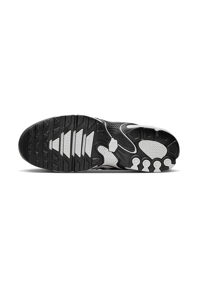 Semelle de chaussure de sport en noir et blanc avec une semelle en caoutchouc texturée, comportant des motifs de traction distincts et des coussinets de soutien pour l'adhérence et le confort.