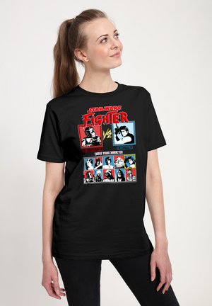 Zwart T-shirt met een grafische print met stripstijl illustraties van personages, tekst in rood en blauw, en contrasterende accenten.