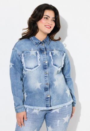 Chaqueta de mezclilla azul con patrones de estrellas, bordes deshilachados y acentos de strass. Dos bolsillos en el pecho con cierre de botón y un cuello tipo solapa.