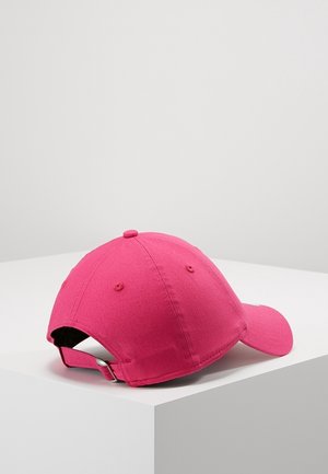 Bright pink baseball cap with adjustable strap and metal buckle, placed on a white cornered surface against a plain gray background.