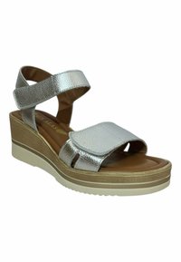 Sandalias de cuña metálicas plateadas con correas texturizadas, tapa frontal ajustable y plantilla acolchada. La suela presenta un diseño en capas.