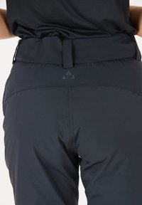 Zwarte high-waisted broek van een soepel stof, met een rechthoekige tailleband voorzien van een riemlus en een subtiele logo op de achterkant.