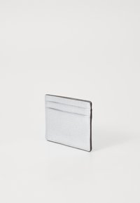 Zilveren leren kaarthouder met een gestructureerde afwerking, rechthoekige vorm en drie kaartsleuven aan één rand.