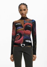 Pikad varrukadega pluus, millel on kollaaž värvilistest huultest ja silmadest, valmistatud venivast materjalist, koos musta vöö ja südamekujulise pandlaga.