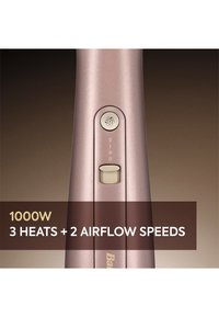 Close-up van het handvat van een haardroger in roségoud met de aan/uit-knop, de schakelaar voor de luchtsnelheid en de tekst "1000W 3 warmte-instellingen + 2 luchtsnelheden" op een bruine achtergrond.