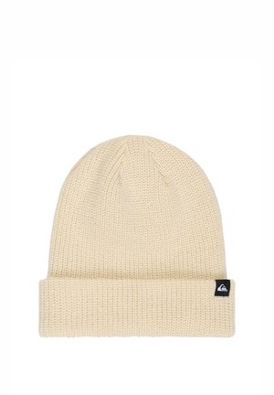 Beige knitted beanie hat with a folded cuff and a small black logo tag on the side.