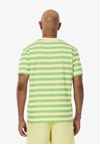 Korte mouwen t-shirt in lichtgroen en pale gele horizontale strepen, gemaakt van katoen, met een ronde hals en rechte zoom.