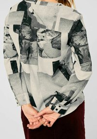 Camicia a maniche lunghe con stampa fotografica in bianco e nero, caratterizzata da una vestibilità rilassata, polsi con bottoni e un tessuto leggermente testurizzato.