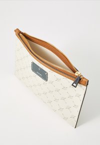 Une pochette de couleur crème avec un motif floral et une fermeture éclair en bronze, comportant une étiquette de marque portant la mention "JOOP!" à l'avant.