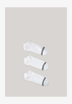 Biele členkové ponožky s čiernymi prúžkami na vrchu; hladká textúra; tri páry vystavené vedľa seba na svetlom pozadí.