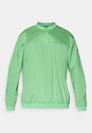 Lys grønn genserjakke med mandarinkrage, elastisk midje, lange ermer og merkevare på brystet. Glatt, lett stoff.