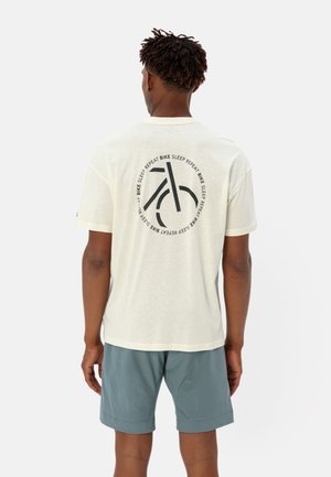 Lichtgekleurde katoenen t-shirt met een cirkelvormige zwarte graphic van een fiets en de tekst "Bike Sleep Repeat." Korte mouwen en een relaxte pasvorm.