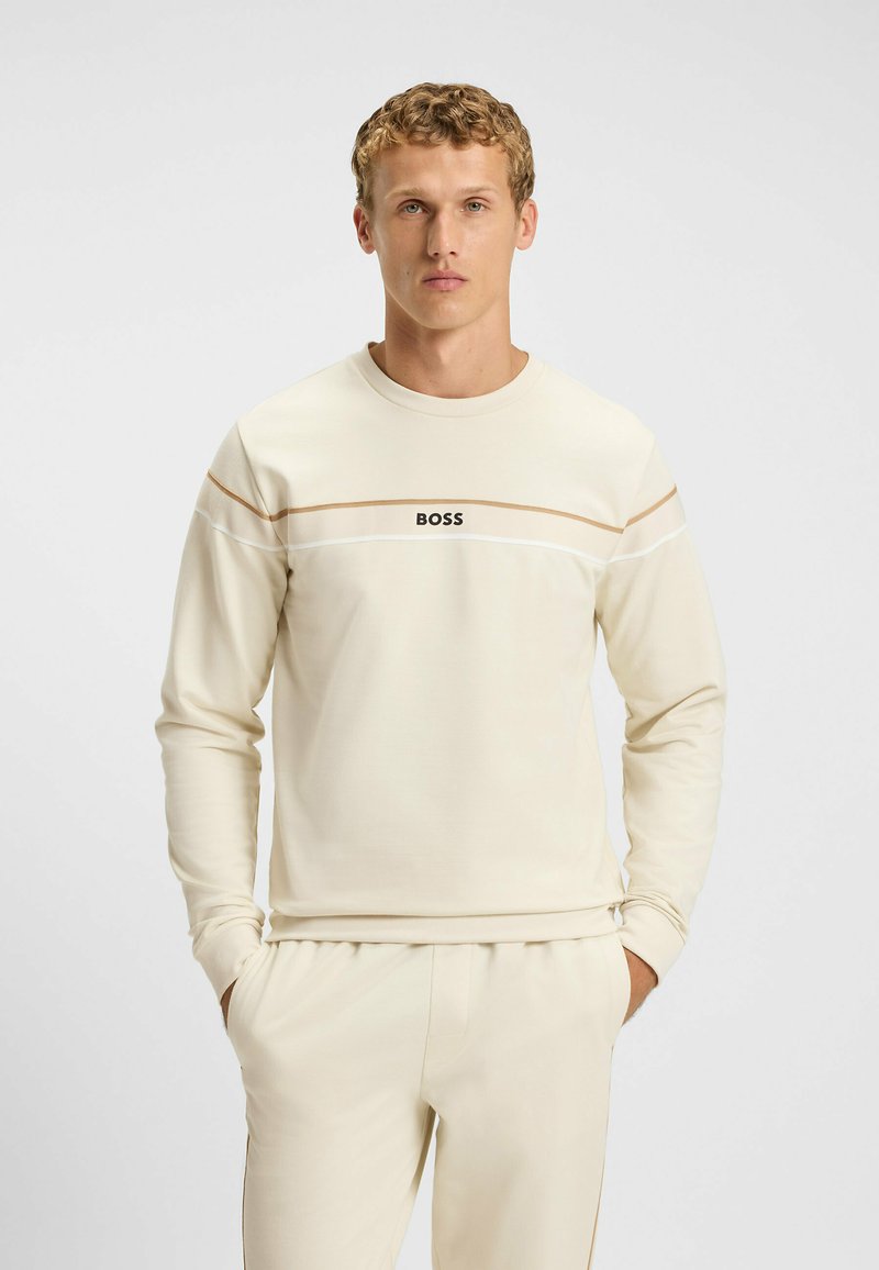 Lichtbeige sweatshirt met lange mouwen, ronde hals en contrasterende horizontale strepen. Bevat een zwart "BOSS" logo op de borst.