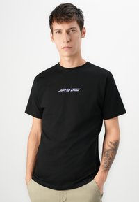 Zwart katoenen T-shirt met een wit en paars "Santa Cruz" logo op de borst. Korte mouwen en een klassieke ronde halslijn.